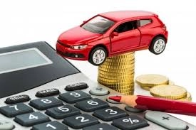 A red toy car perched on a stack of gold coins resting on a calculator next to a red pencil, representing an Auto Loan Calculator concept for estimating vehicle payments.
